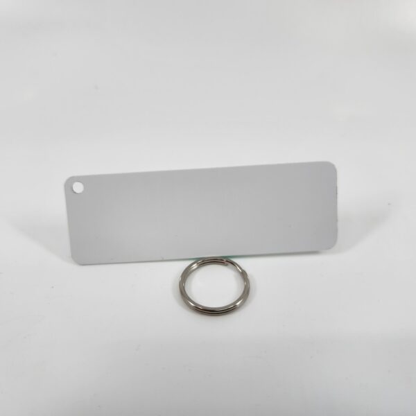 A white panel with a hole in the corner for a key ring on a white background.
